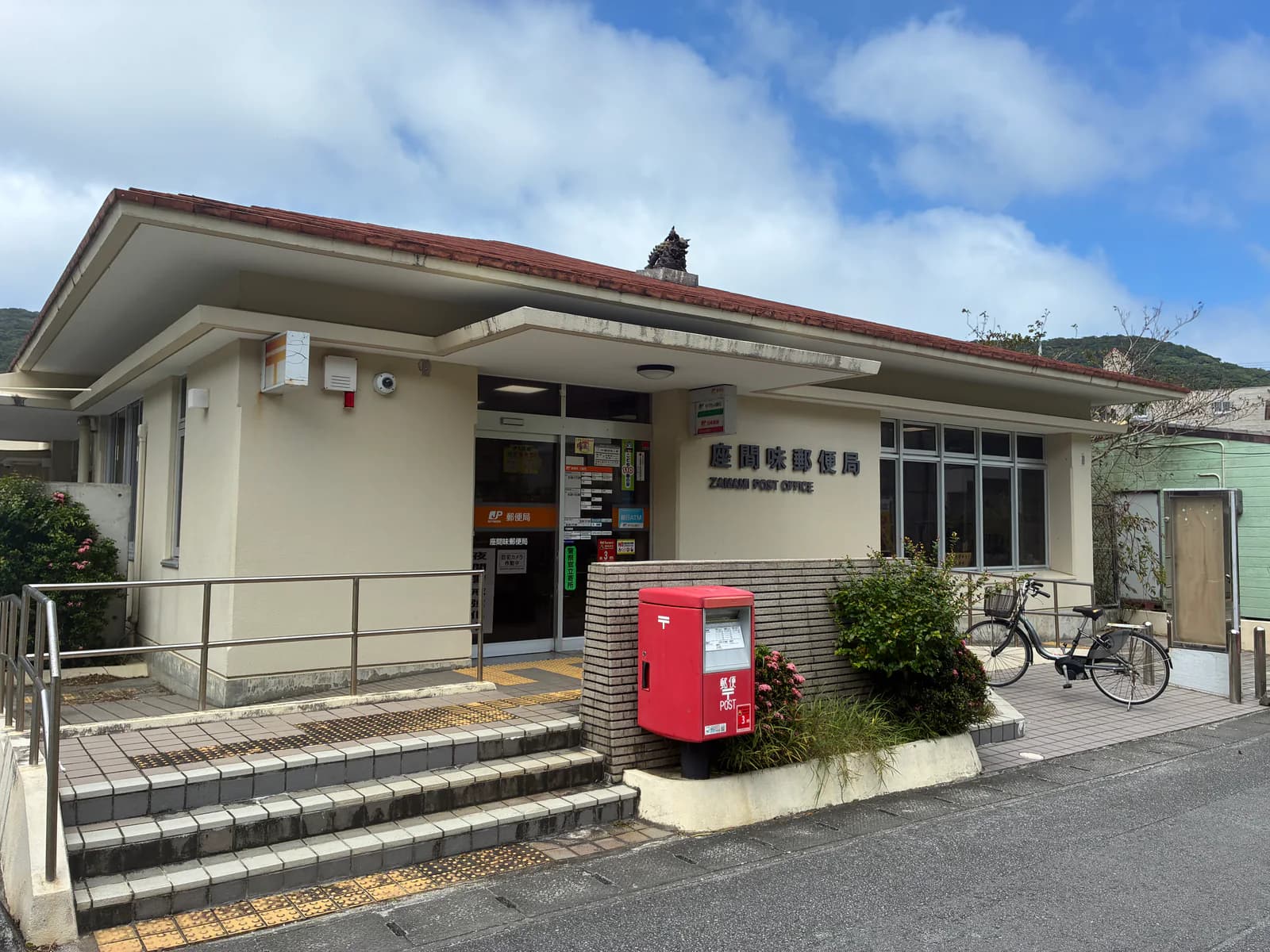 座間味郵局建築與入口的銀行 ATM 標示