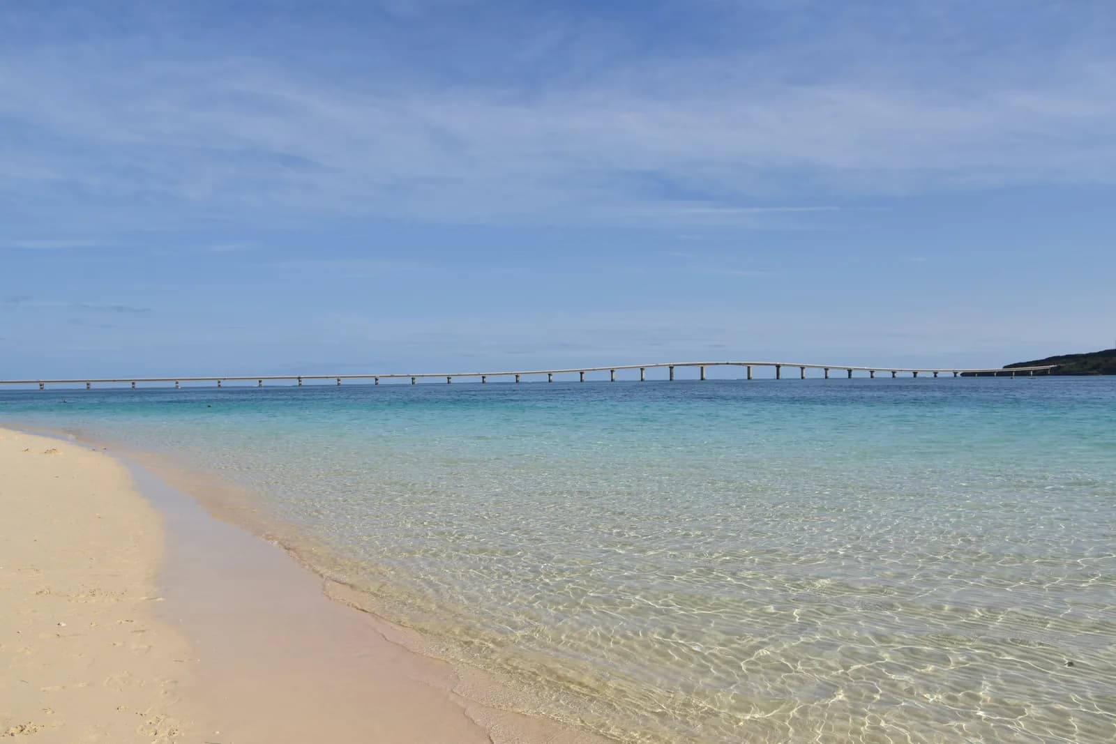 与那覇前浜の砂浜と海、その奥に延びる来間大橋